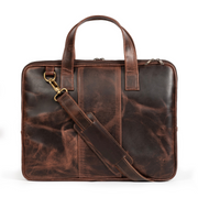 A dark brown leather briefcase with a removable shoulder strap and brass hardware, featuring a sleek and compact design.
